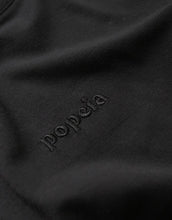 Laden Sie das Bild in den Galerie-Viewer, Schwarzes Langarmshirt von Popeia aus 100 % Bio-Baumwolle mit Relaxed Fit, breitem Kragen und Kindness-Spruch im Nacken.