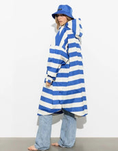 Laden Sie das Bild in den Galerie-Viewer, Raincoat Bold Stripes Blue/Sand von VIVI MARI – wasserdichtes Cape aus recyceltem Polyester in Oversize-Passform mit Kapuze, Klettverschluss-Manschetten und seitlichen Taschen, nachhaltig und funktional für Stadt, Fahrrad und Alltag