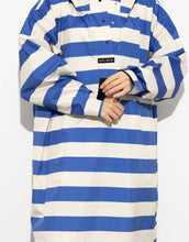 Laden Sie das Bild in den Galerie-Viewer, Raincoat Bold Stripes Blue/Sand von VIVI MARI – wasserdichtes Cape aus recyceltem Polyester in Oversize-Passform mit Kapuze, Klettverschluss-Manschetten und seitlichen Taschen, nachhaltig und funktional für Stadt, Fahrrad und Alltag