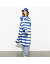 Laden Sie das Bild in den Galerie-Viewer, Raincoat Bold Stripes Blue/Sand von VIVI MARI – wasserdichtes Cape aus recyceltem Polyester in Oversize-Passform mit Kapuze, Klettverschluss-Manschetten und seitlichen Taschen, nachhaltig und funktional für Stadt, Fahrrad und Alltag