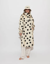 Laden Sie das Bild in den Galerie-Viewer, Raincoat Bold Stripes Dots Black/Sand von VIVI MARI: Langer, wasserdichter Regenmantel im Streifen-Design, oversized geschnitten mit Kapuze, Knopfleiste, Klettverschluss-Manschetten und praktischen Taschen – nachhaltig aus recyceltem Polyester gefertigt.