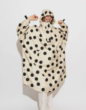 Laden Sie das Bild in den Galerie-Viewer, Raincoat Bold Stripes Dots Black/Sand von VIVI MARI: Langer, wasserdichter Regenmantel im Streifen-Design, oversized geschnitten mit Kapuze, Knopfleiste, Klettverschluss-Manschetten und praktischen Taschen – nachhaltig aus recyceltem Polyester gefertigt.