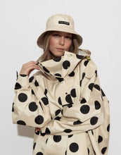 Laden Sie das Bild in den Galerie-Viewer, Raincoat Bold Stripes Dots Black/Sand von VIVI MARI: Langer, wasserdichter Regenmantel im Streifen-Design, oversized geschnitten mit Kapuze, Knopfleiste, Klettverschluss-Manschetten und praktischen Taschen – nachhaltig aus recyceltem Polyester gefertigt.