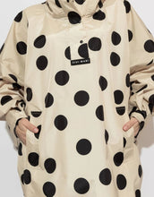 Laden Sie das Bild in den Galerie-Viewer, Raincoat Bold Stripes Dots Black/Sand von VIVI MARI: Langer, wasserdichter Regenmantel im Streifen-Design, oversized geschnitten mit Kapuze, Knopfleiste, Klettverschluss-Manschetten und praktischen Taschen – nachhaltig aus recyceltem Polyester gefertigt.