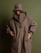 Laden Sie das Bild in den Galerie-Viewer, VIVI MARI Raincoat in Dark Mushroom, wasserdichtes Oversize Cape mit Kapuze.