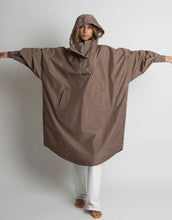Laden Sie das Bild in den Galerie-Viewer, VIVI MARI Raincoat in Dark Mushroom, wasserdichtes Oversize Cape mit Kapuze.