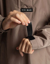 Laden Sie das Bild in den Galerie-Viewer, VIVI MARI Raincoat in Dark Mushroom, wasserdichtes Oversize Cape mit Kapuze.