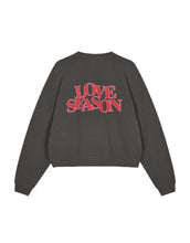 Laden Sie das Bild in den Galerie-Viewer, Light Love Season Sweater von OH APRIL in Graphite mit großem Love-Season-Print auf dem Rücken und kleinem Logo auf der Brust, entspannte Passform, leicht verkürzt, aus weichem Baumwollmix mit klassischem Rundhalsausschnitt.