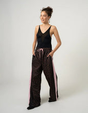 Laden Sie das Bild in den Galerie-Viewer, OH APRIL Trackpants Kael Leo Mocha – weite Damenhose mit rosa Seitenstreifen, Leo-Muster, Wide Leg Fit, Größen XS–XL.