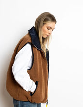 Laden Sie das Bild in den Galerie-Viewer, Reversible Bomber Weste von Vivi Mari in Navy und Karamell, tragbar mit glattem Nylon oder weichem Fleece außen, oversized geschnitten mit Reißverschluss und Taschen, ideal für Layering und urbane Looks.