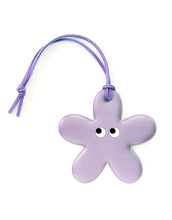 Laden Sie das Bild in den Galerie-Viewer, Blumenförmiger Reflektor-Anhänger Flower Lilac von Firefly Reflectors in Flieder aus reflektierendem Material mit Lederband, ca. 8 cm – dekorativ und funktional.