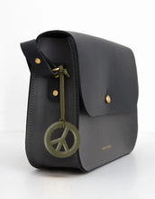 Laden Sie das Bild in den Galerie-Viewer, Olivgrüner Reflektor-Anhänger in Peace-Form von Firefly Reflectors aus reflektierendem Material mit Lederband, ca. 8 cm – stylisch, sicher und aussagekräftig.