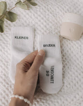 Laden Sie das Bild in den Galerie-Viewer, Babysocken Kleiner Bruder von Eulenschnitt, 80% Baumwolle, 18% Polyamid, 2% Elastan, mit Schriftzug „Kleiner Bruder“ auf dem Bündchen.