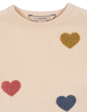 Laden Sie das Bild in den Galerie-Viewer, Beige Lou Sweat Dress von Konges Sløjd mit bunten Herz-Patches, ausgestelltem Rock und Rundhalsausschnitt.