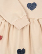 Laden Sie das Bild in den Galerie-Viewer, Beige Lou Sweat Dress von Konges Sløjd mit bunten Herz-Patches, ausgestelltem Rock und Rundhalsausschnitt.