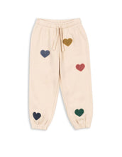 Laden Sie das Bild in den Galerie-Viewer, Beige-rosefarbene Lou Sweatpants von Konges Sløjd mit bunten Herzen und elastischem Bund.