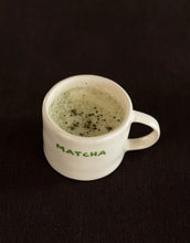 Laden Sie das Bild in den Galerie-Viewer, SISI House of Style Henkelbecher Matcha, off-white mit grünem Schriftzug, handgefertigt, 9 x 9 x 7 cm.
