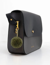 Laden Sie das Bild in den Galerie-Viewer, Reflektierender Pom Pom Anhänger in Olivgrün von Firefly Reflectors aus flauschigem Garn mit reflektierendem Faden – dekoratives und sicheres Accessoire für Taschen und Rucksäcke.