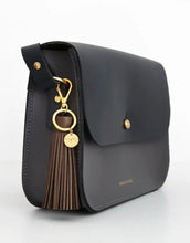 Laden Sie das Bild in den Galerie-Viewer, Reflektierender Taschenanhänger Quaste Schokolade von Firefly Reflectors – weiches, lederähnliches Material mit Handstickerei, Schlüsselring und Metallhaken, stylisches Accessoire für bessere Sichtbarkeit.