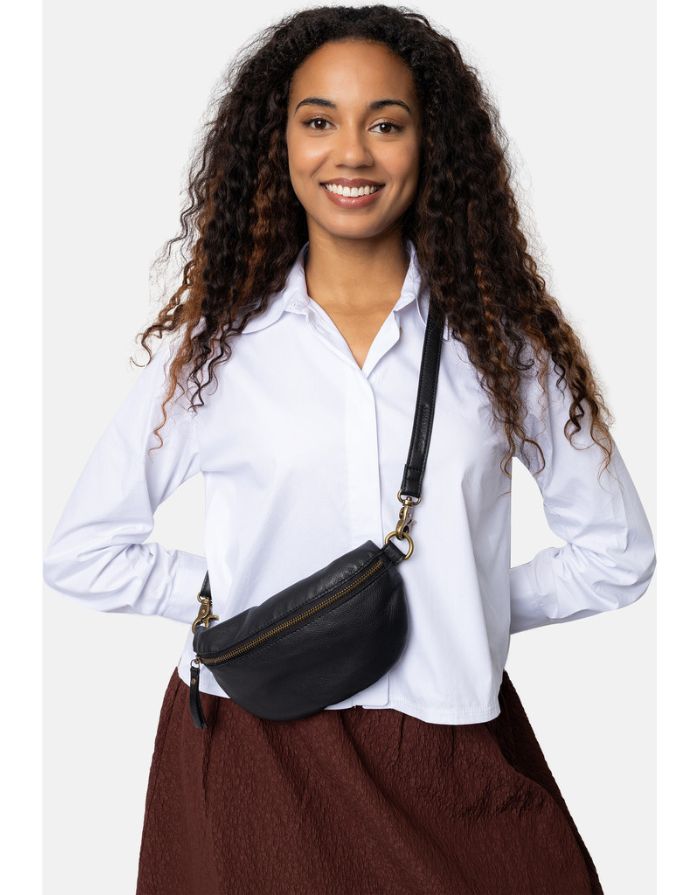  Schwarze Gisela Bumbag von RE:DESIGNED aus hochwertigem Rindsleder mit verstellbarem Schultergurt und zeitlosem Design am Model