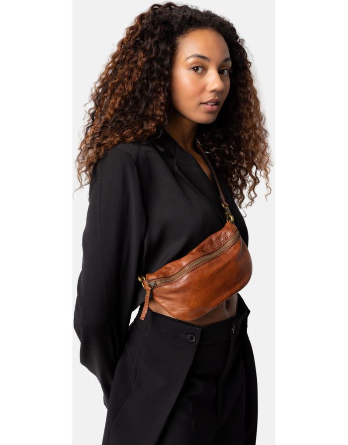 Braune Gisela Bumbag von RE:DESIGNED aus hochwertigem Rindsleder in der Farbe Walnut mit verstellbarem Schultergurt und zeitlosem Design an Model stehend