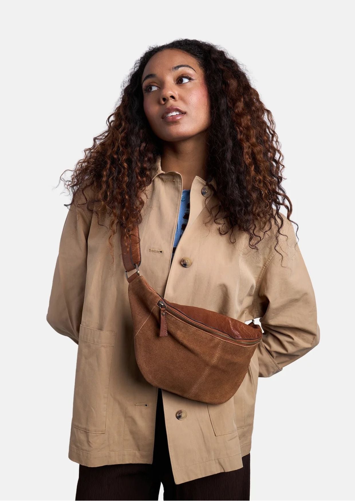 Bauchtasche Selma von Re:Designed in Walnut aus weichem Veloursleder mit verstellbarem Crossbody-Gurt und Reißverschluss.