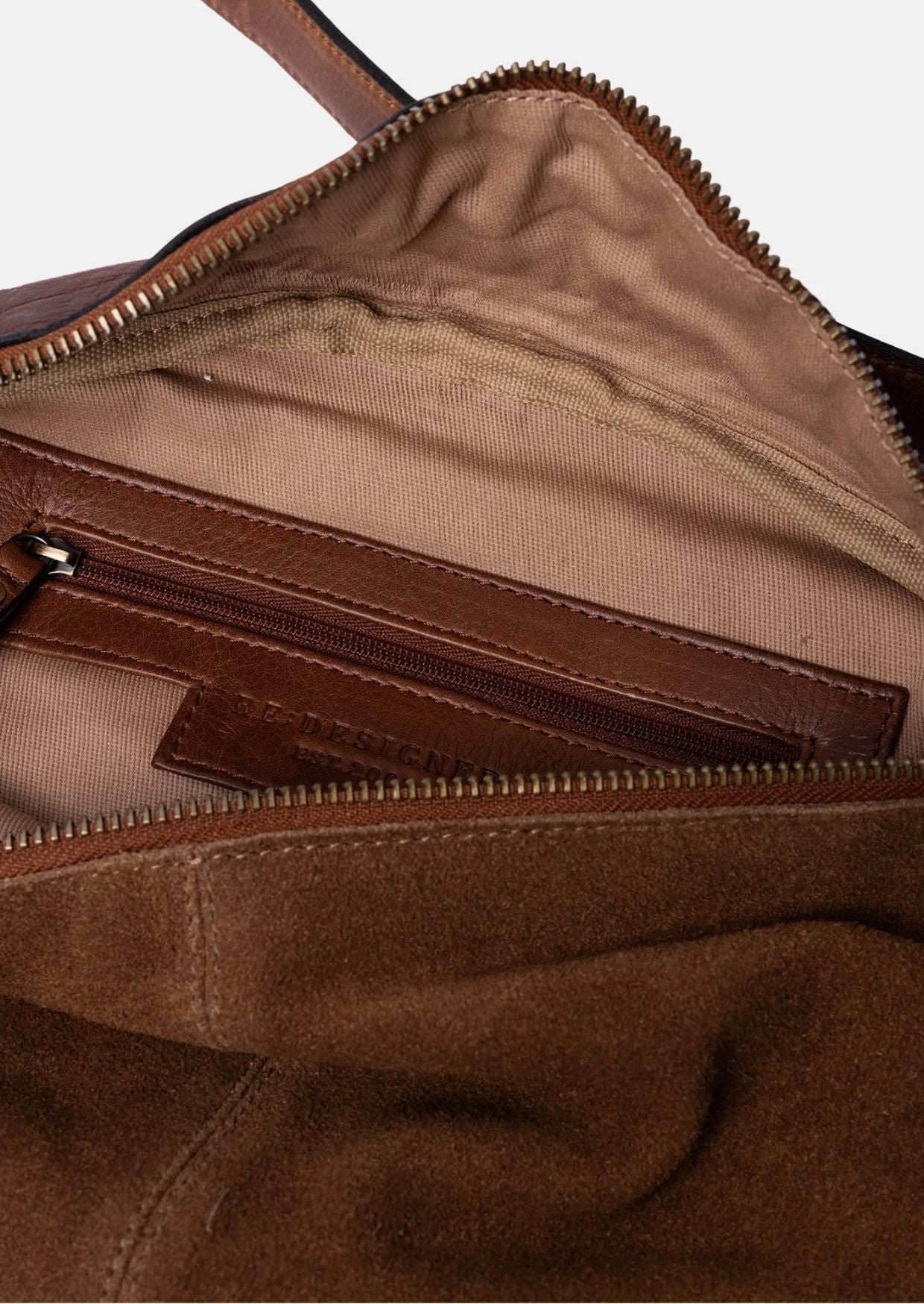 Bauchtasche Selma von Re:Designed in Walnut aus weichem Veloursleder mit verstellbarem Crossbody-Gurt und Reißverschluss.
