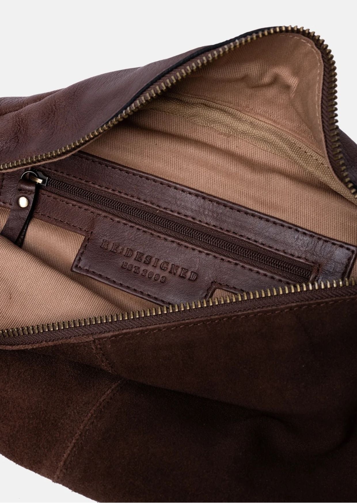 Bauchtasche Selma von Re:Designed in Woodsmoke aus weichem Veloursleder mit verstellbarem Crossbody-Gurt und Reißverschluss.