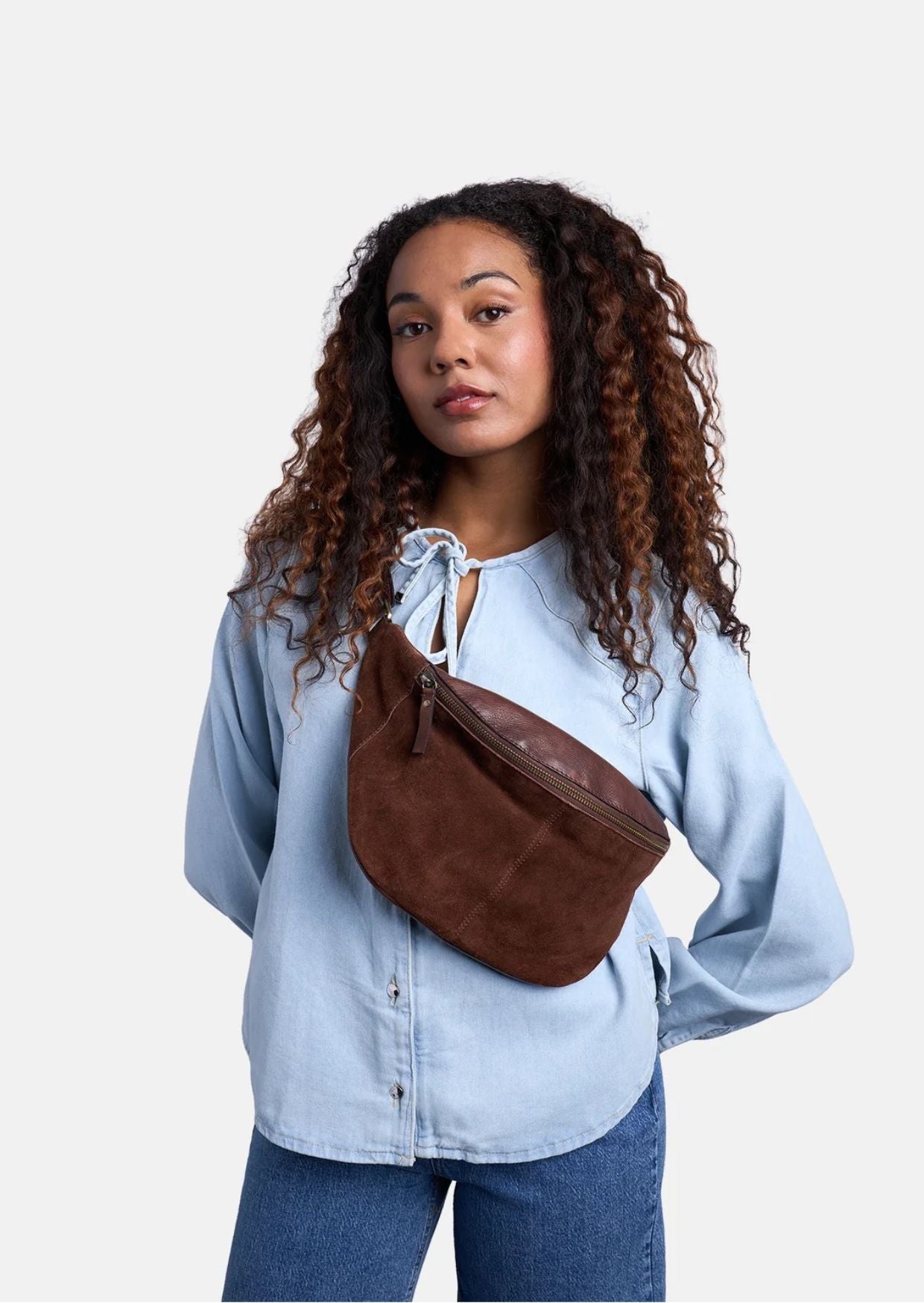 Bauchtasche Selma von Re:Designed in Woodsmoke aus weichem Veloursleder mit verstellbarem Crossbody-Gurt und Reißverschluss.