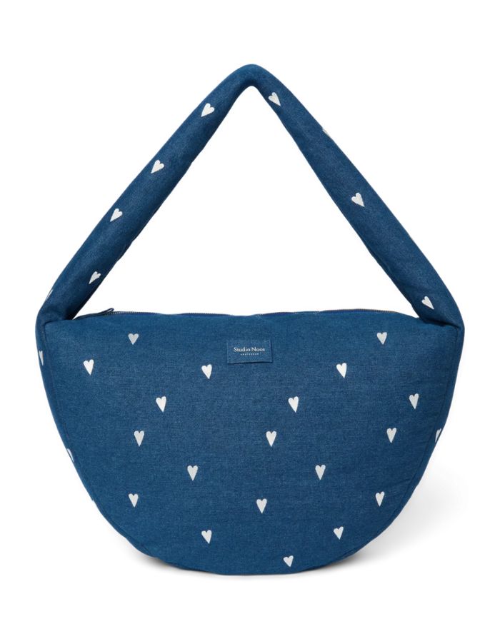 Studio Noos Cross Body Umhängetasche aus dunkelblauem gepolstertem Denim mit gestickten weißen Herzen und Platz für einen 13-Zoll-Laptop.