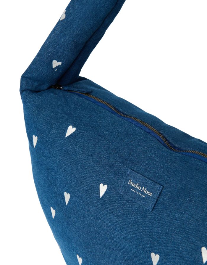 Studio Noos Cross Body Umhängetasche aus dunkelblauem gepolstertem Denim mit gestickten weißen Herzen und Platz für einen 13-Zoll-Laptop, nahansicht. 