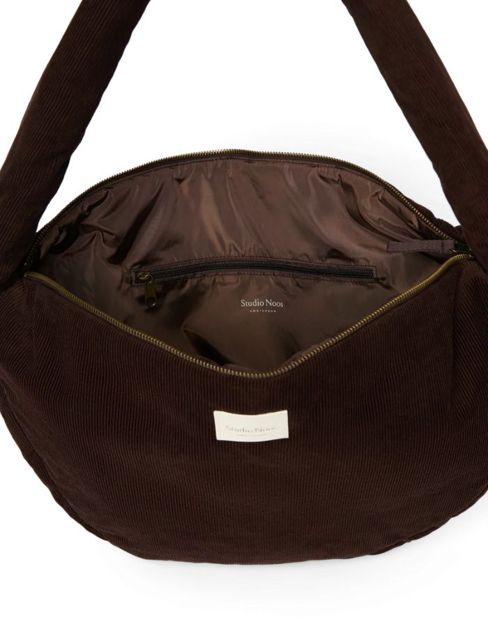 Studio Noos Crossbody Umhängetasche Rib Puffy in Dark Brown aus gepolstertem Rib-Stoff mit Seitentaschen und Platz für einen 13-Zoll-Laptop von Innen.