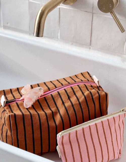 Kosmetiktasche Sofia von Rose in April in Rosa mit braunen Streifen neben einer anderen Kosmetiktasche