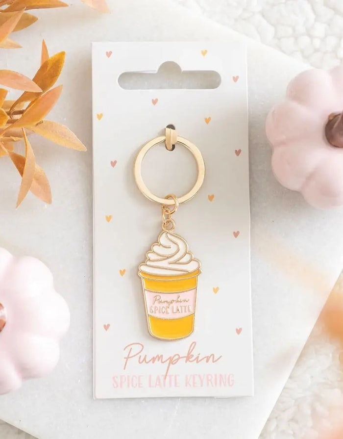 Schlüsselanhänger in von Form eines Pumpkin Spice Lattes von Something Different auf einem Brett