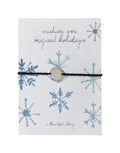Schmuck-Postkarte Crystals von A Beautiful Story mit Schneekristallen, „wishing you magical holidays“-Schriftzug und Armband mit Sternanhänger.