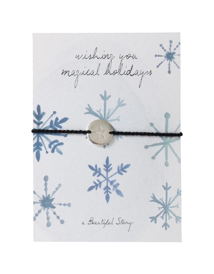 Schmuck-Postkarte Crystals von A Beautiful Story mit Schneekristallen, „wishing you magical holidays“-Schriftzug und Armband mit Sternanhänger.