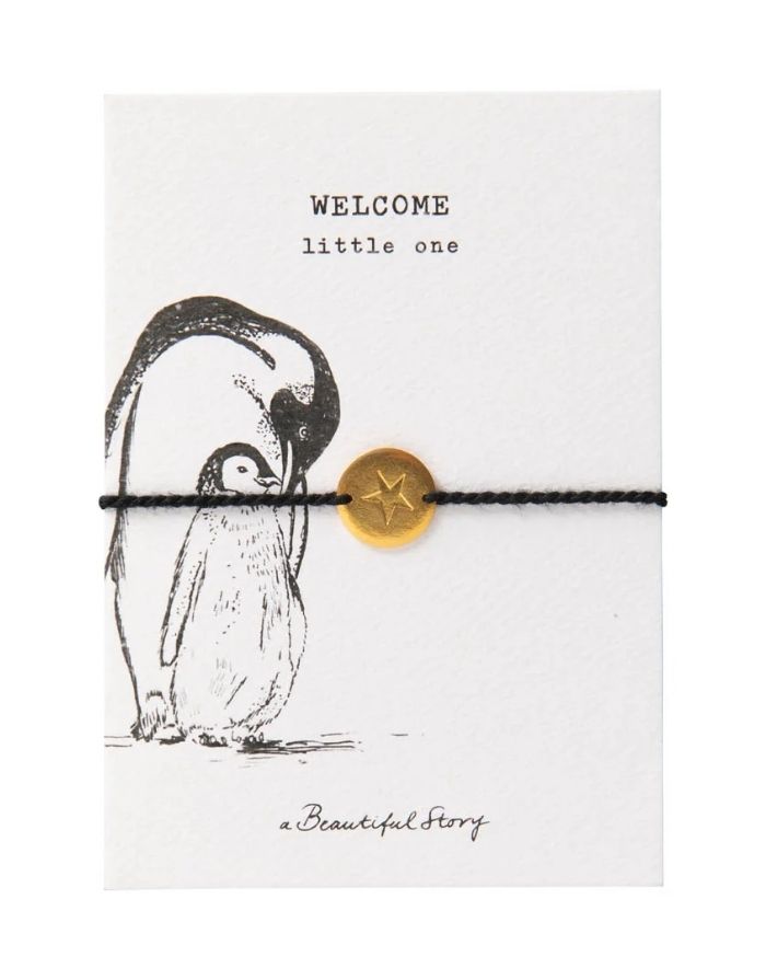 Schmuck-Postkarte Pinguin von A Beautiful Story mit „welcome little one“-Motiv und schwarzem Armband mit goldfarbenem Sternanhänger.