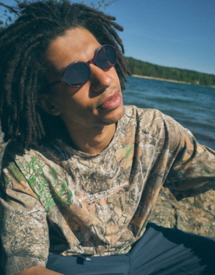 CHPO Marlene Sonnenbrille mit bordeauxroter Fassung, braunen Gläsern und UV400-Schutz aus recyceltem Kunststoff getragen.