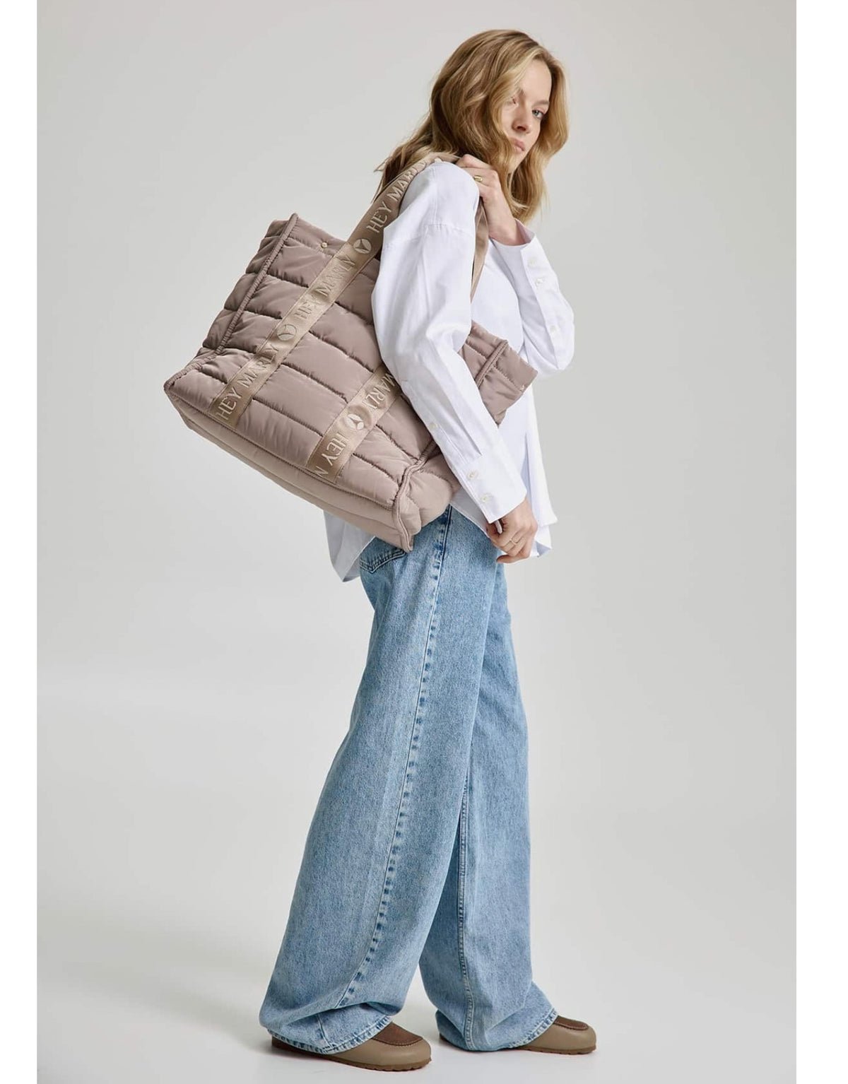 Große Hey Marly Best Buddy Tasche in Mocha aus weichem, leichtem Material mit Signature-Henkeln und geräumigem Innenfach am Model von der Seite