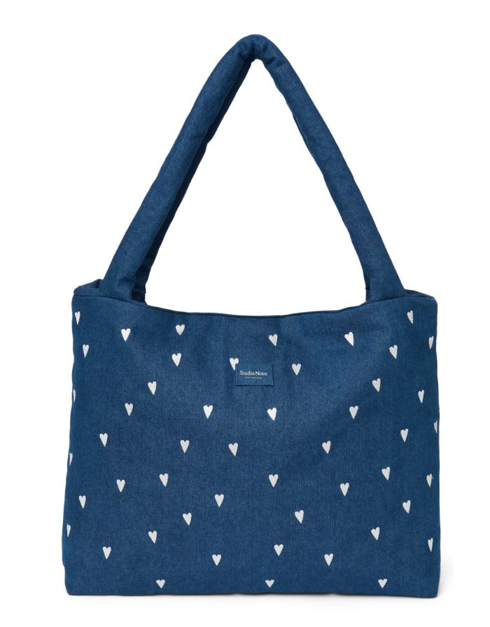 Studio Noos Mom Bag aus dunkelblauem gepolstertem Denim mit weißen Herzen, langen Tragegriffen und geräumigem offenem Hauptfach.