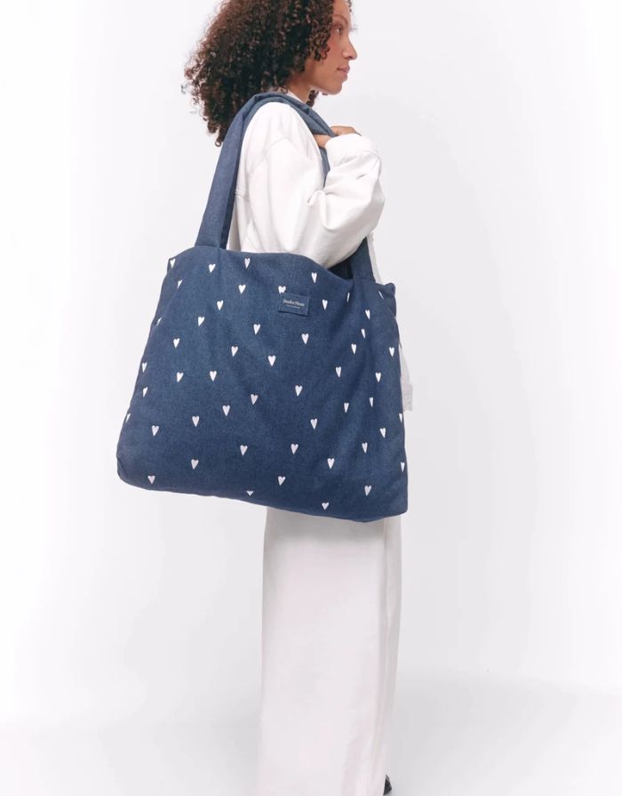 Studio Noos Mom Bag aus dunkelblauem gepolstertem Denim mit weißen Herzen, langen Tragegriffen und geräumigem offenem Hauptfach.