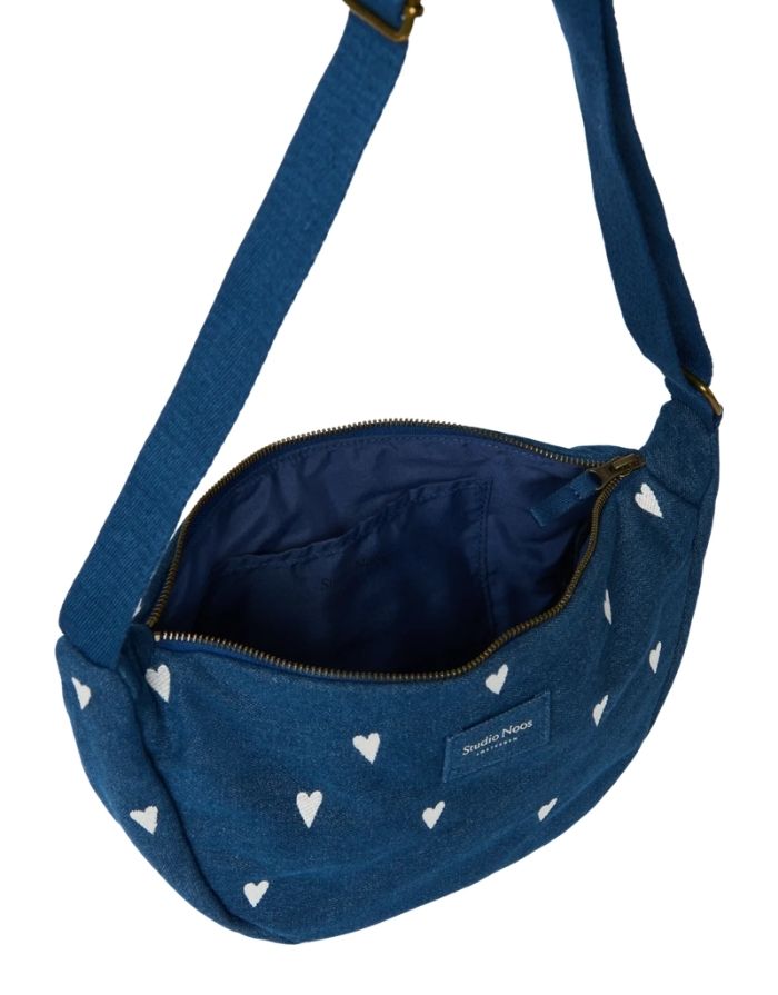 Studio Noos Fanny Pack Denim Blue White Hearts aus dunkelblauem gepolstertem Denim mit gestickten weißen Herzen und verstellbarem Trageriemen geöffnet.