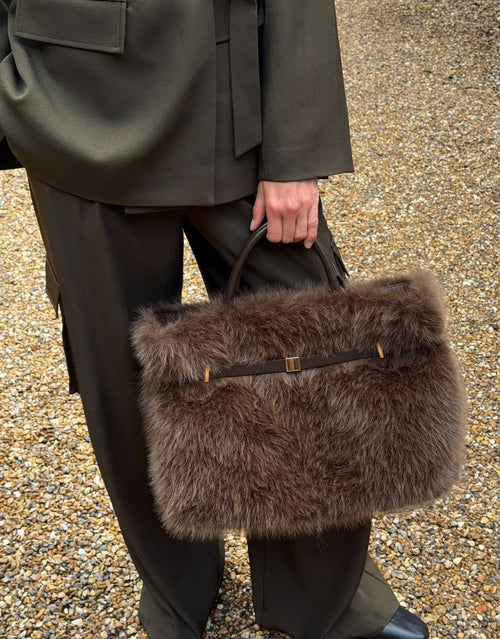 Braune Faux Fur Belted Tasche von Gina Tricot aus flauschigem Kunstfell mit Kunstleder-Details und goldfarbenen Metall-Akzenten am Model