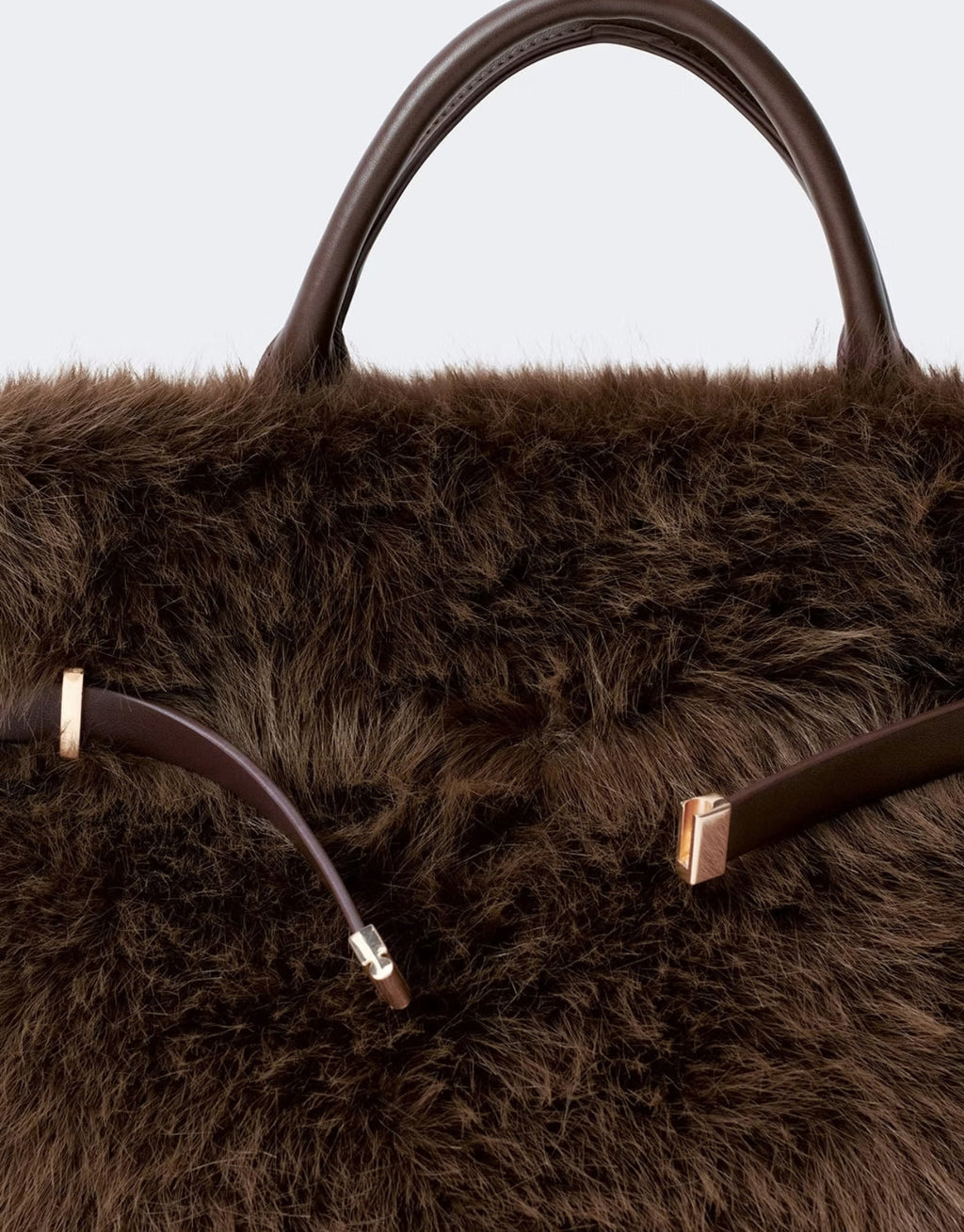 Braune Faux Fur Belted Tasche von Gina Tricot aus flauschigem Kunstfell mit Kunstleder-Details und goldfarbenen Metall-Akzenten im Detail