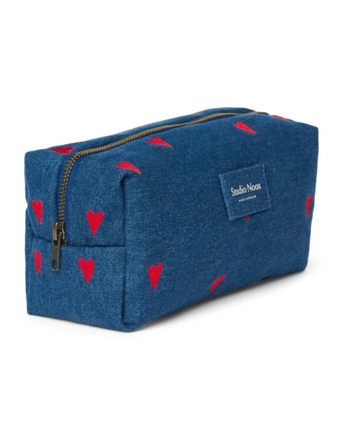 Gepolsterte Kosmetiktasche von Studio Noos aus dunkelblauem Denim mit gestickten roten Herzen und praktischem Stauraum für kleine Essentials seitlich.