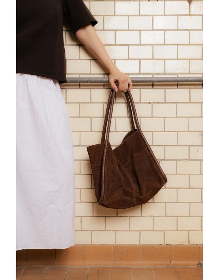  Braune Meno Schultertasche von RE:DESIGNED aus weichem Veloursleder in der Farbe Woodsmoke mit großzügigem Hauptfach und Lederhenkel Hängend