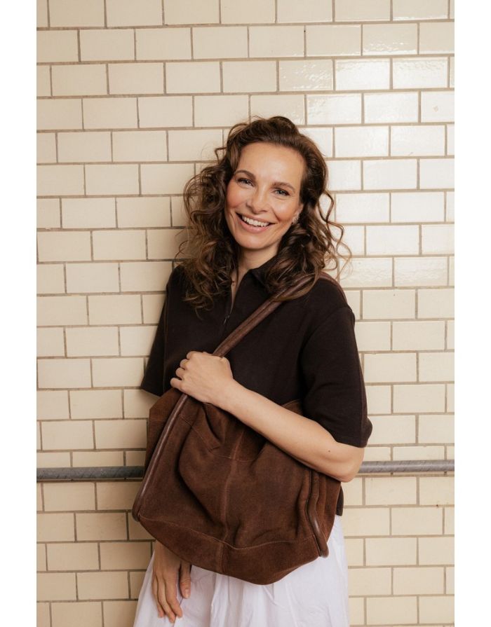 Braune Meno Schultertasche von RE:DESIGNED aus weichem Veloursleder in der Farbe Woodsmoke mit großzügigem Hauptfach und Lederhenkel Am Model