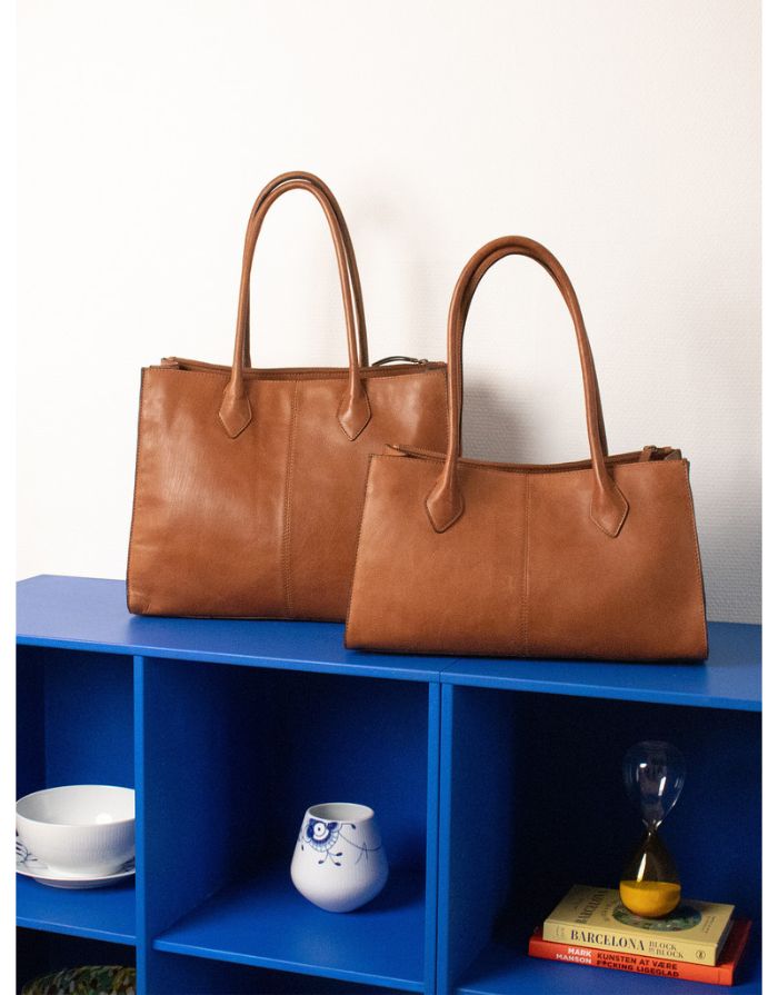  Braune Ora Big Ledertasche von Re:Designed mit großem Hauptfach, praktischen Innenfächern und handgefertigtem Design stehend