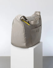 Laden Sie das Bild in den Galerie-Viewer, Padded Hip Bag Oversized von Vivi Mari in Stone, große wasserabweisende Umhängetasche mit zwei Außentaschen, verstellbarem Schultergurt und silbernen Metallakzenten, aus recyceltem Polyester.

