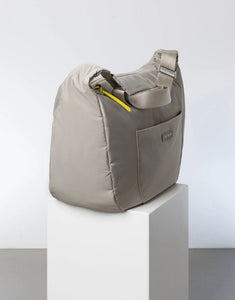 Padded Hip Bag Oversized von Vivi Mari in Stone, große wasserabweisende Umhängetasche mit zwei Außentaschen, verstellbarem Schultergurt und silbernen Metallakzenten, aus recyceltem Polyester.